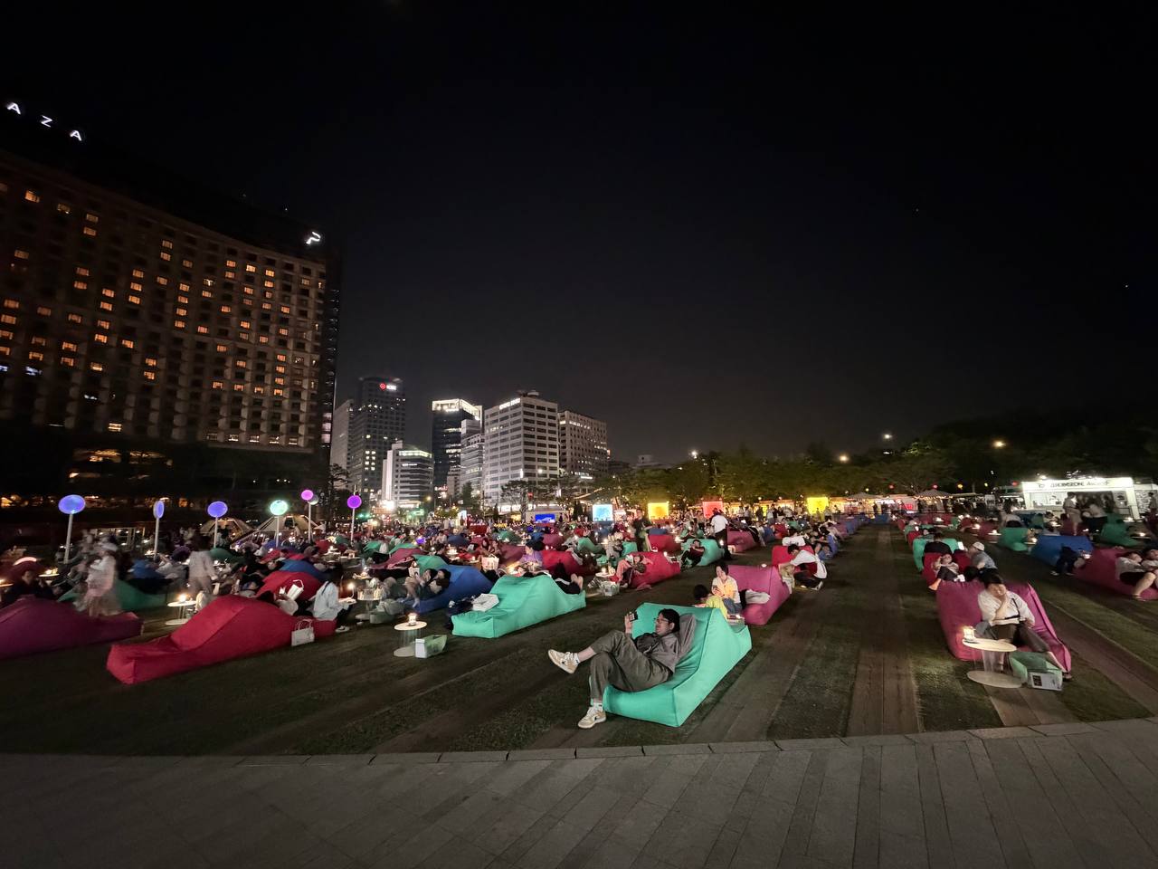 Seoul Outdoor Library at Seoul Plaza with people lounging on colorful bean bag chairs at night