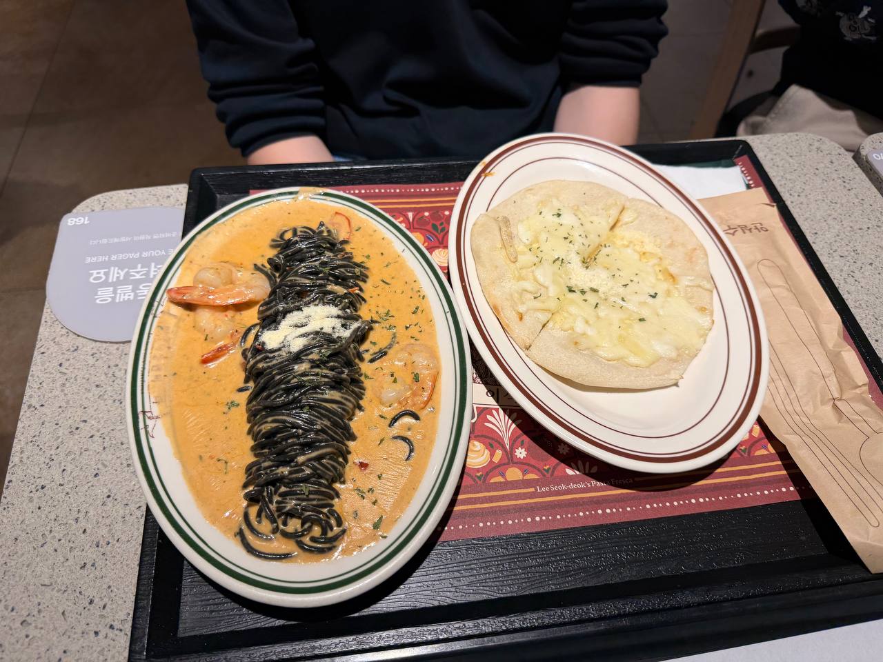 Squid ink rose pasta with shrimp in cream sauce and cheese flatbread at Lotte food court Seoul