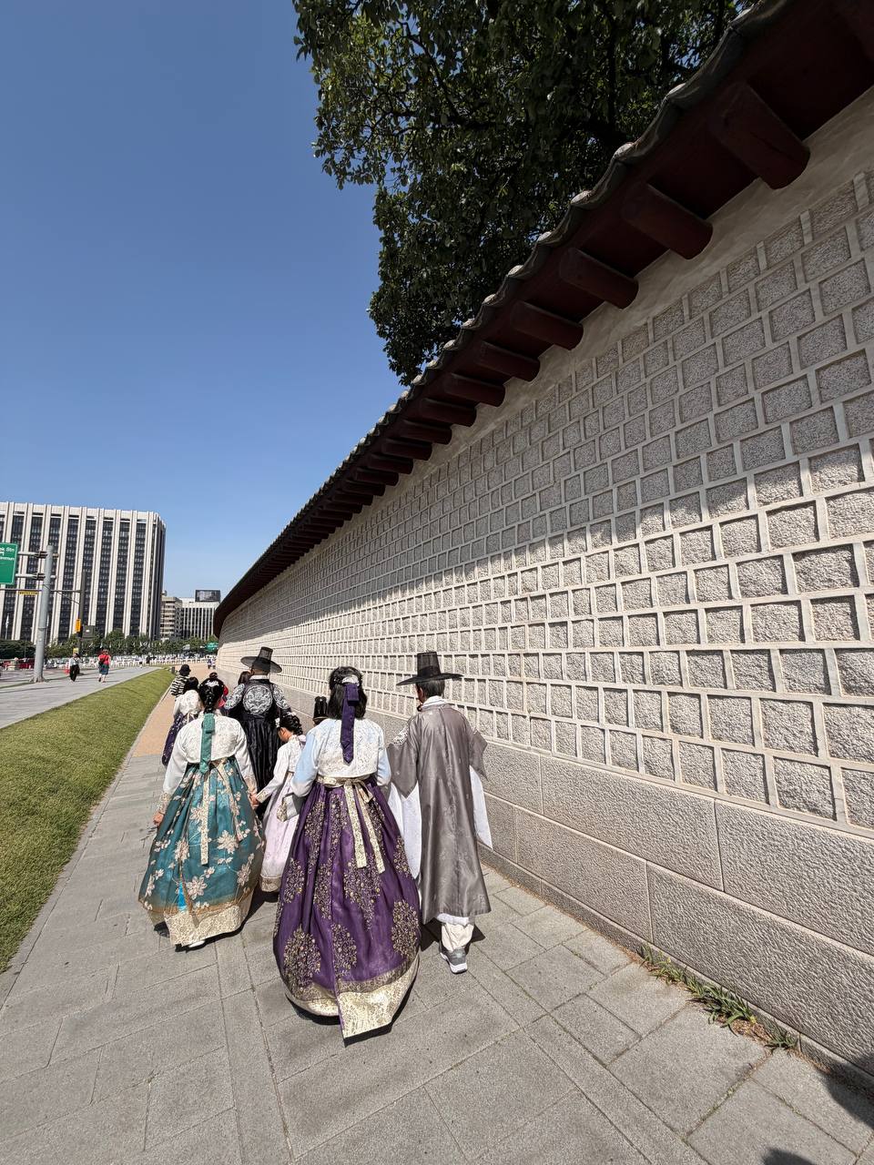 Hanbok wearers walking along Gyeongbokgung Palace wall Seoul