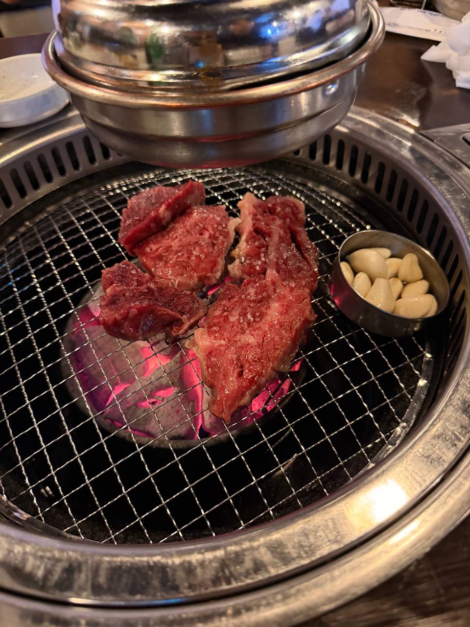 Raw marbled beef on charcoal grill at Hwapo Sikdang