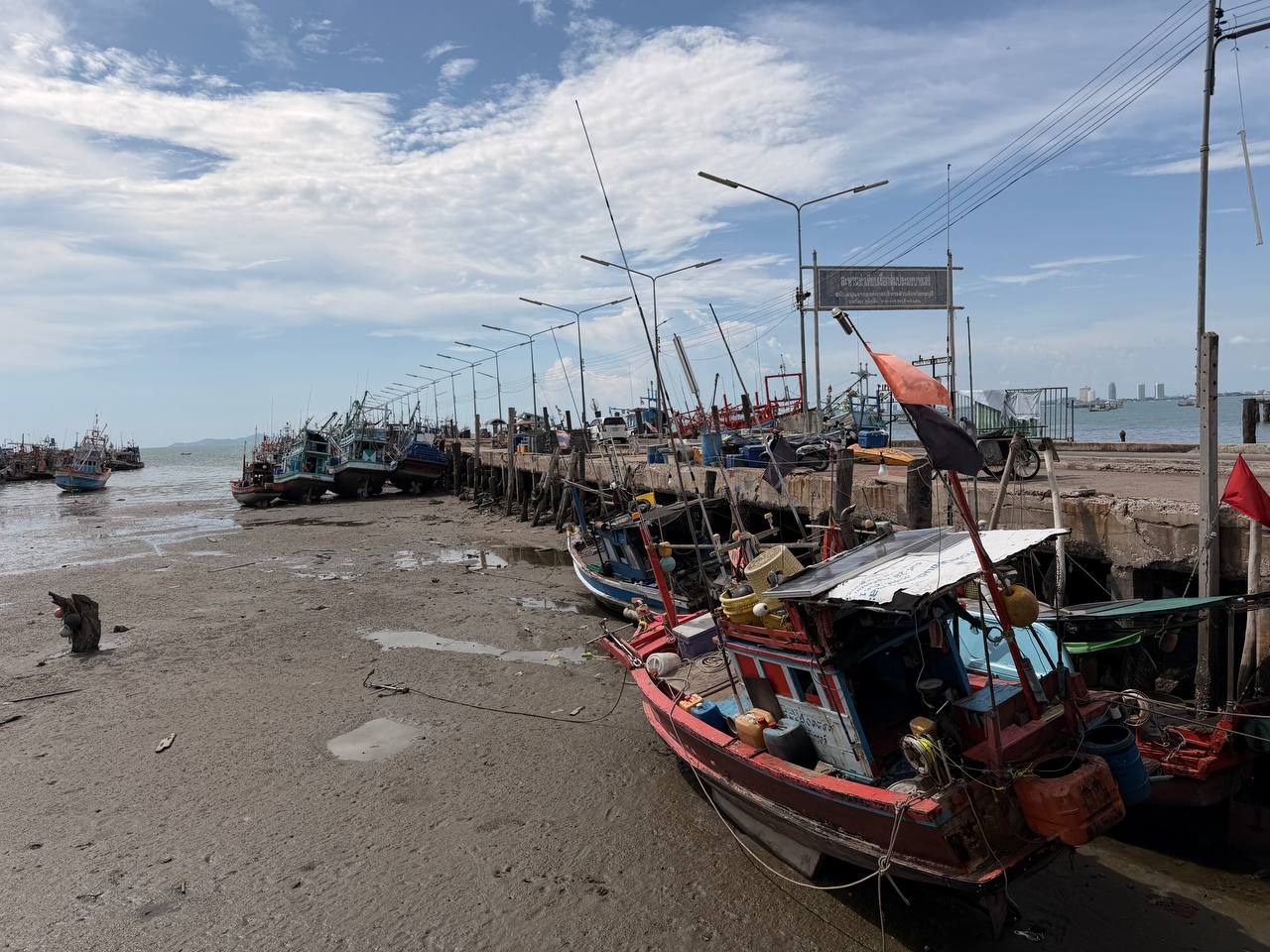 Colorful fishing boats at Bang Saray pier close up Pattaya skyline