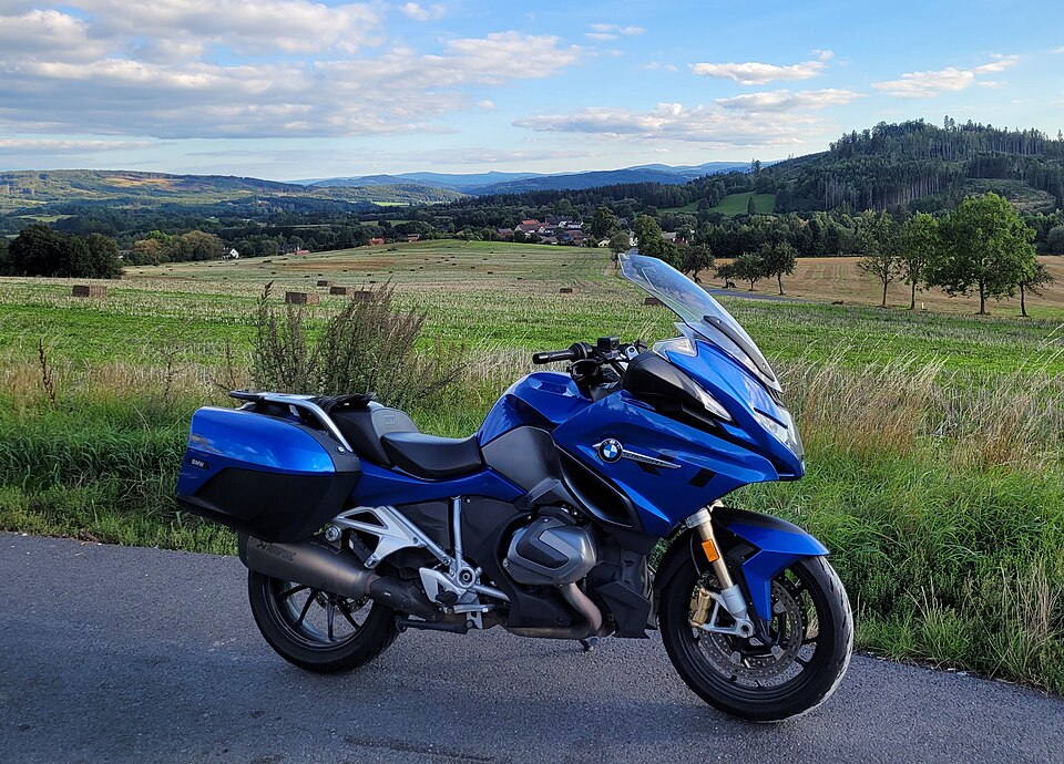 Blue BMW R 1250 RT road-touring motorcycle parked beside a rural road